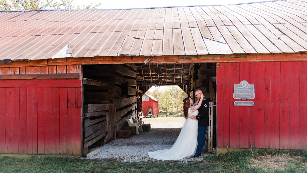 Wedding couple hugging in Whippoorwill Hill's historic red barn.
