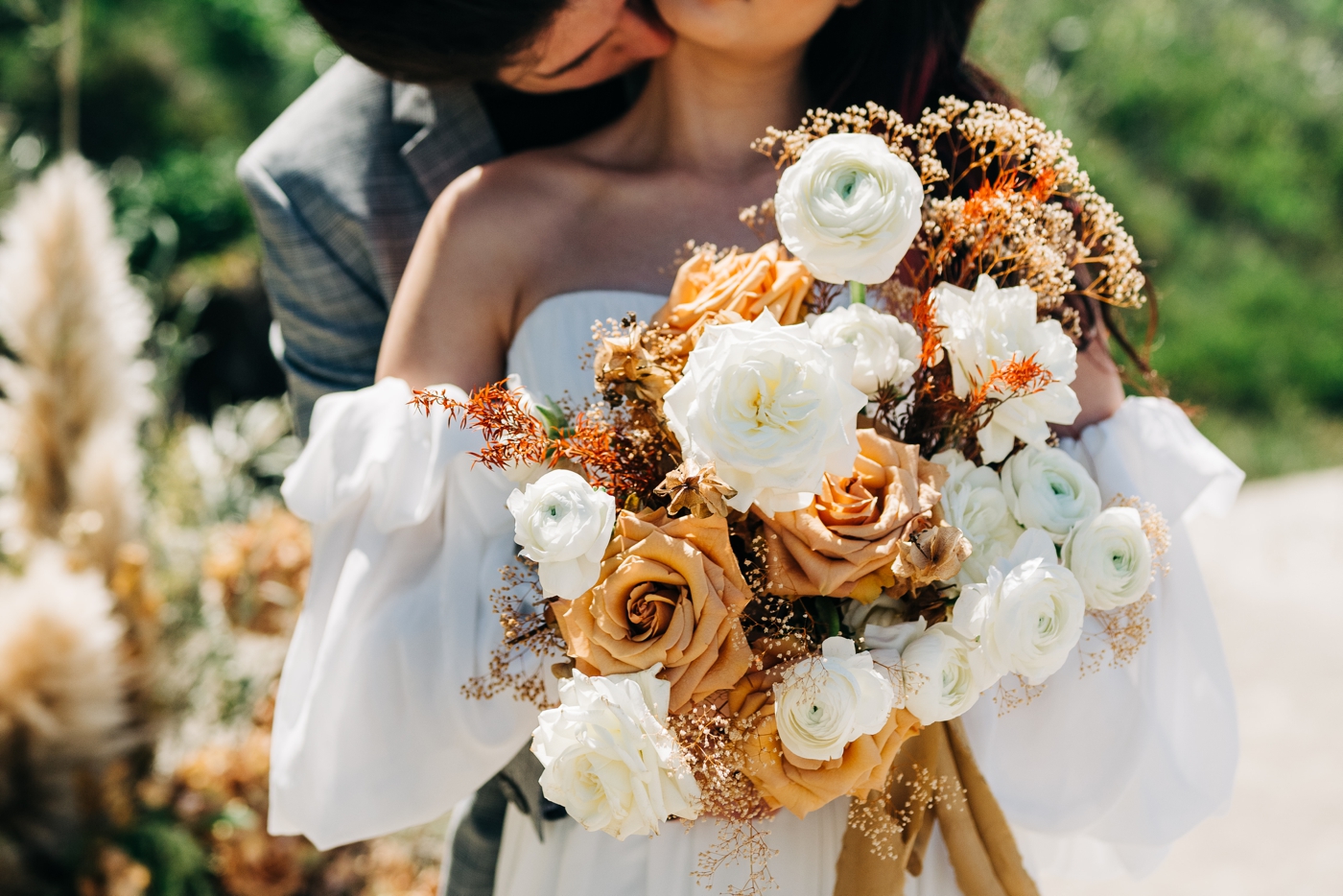 Golden fall bouquet with cream ranunculus and caramel roses by Noble Floral Co.