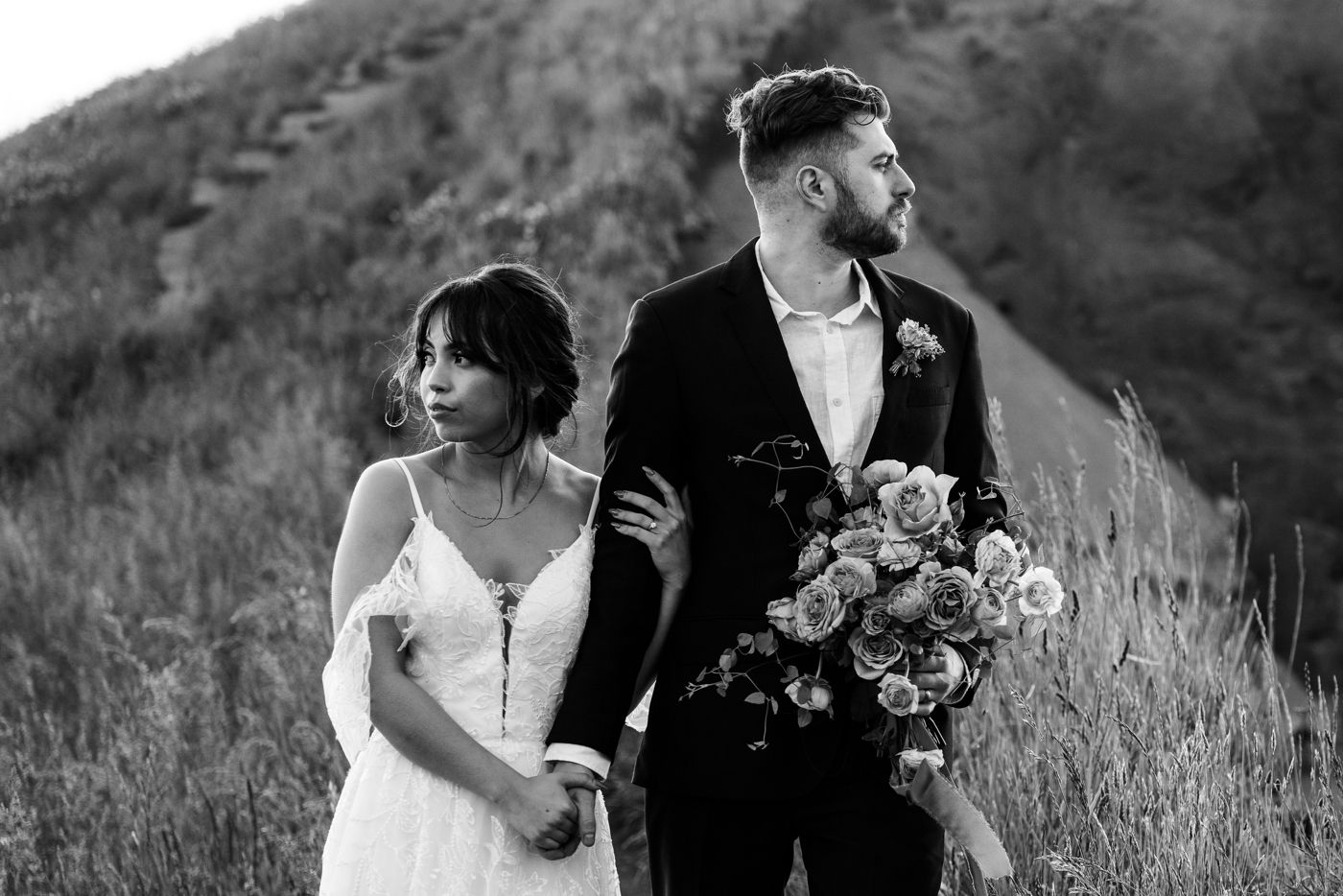 Black and white portrait of a bride and groom, groom holding the bouquet