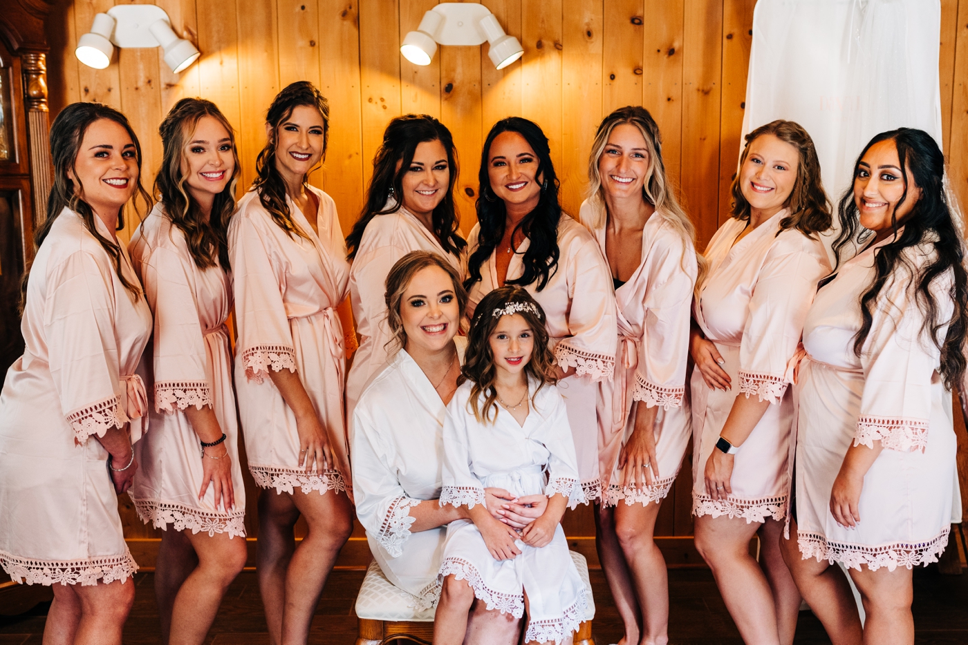 Bride getting ready with bridesmaids in blush robes before wedding in Greenwood