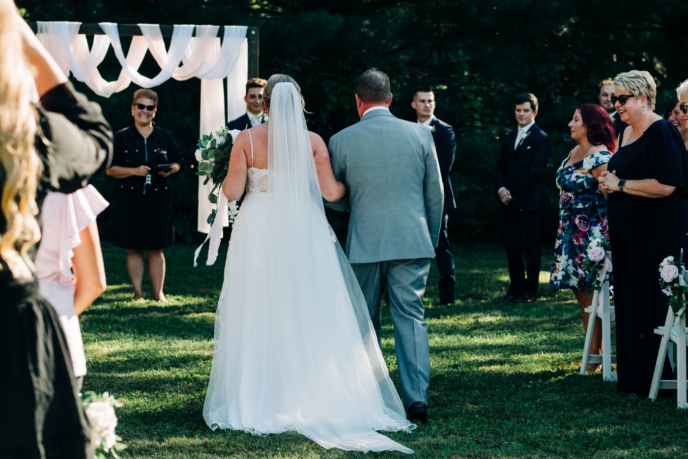 Father of the bride walking down the aisle at backyard wedding ceremony in Greenwood