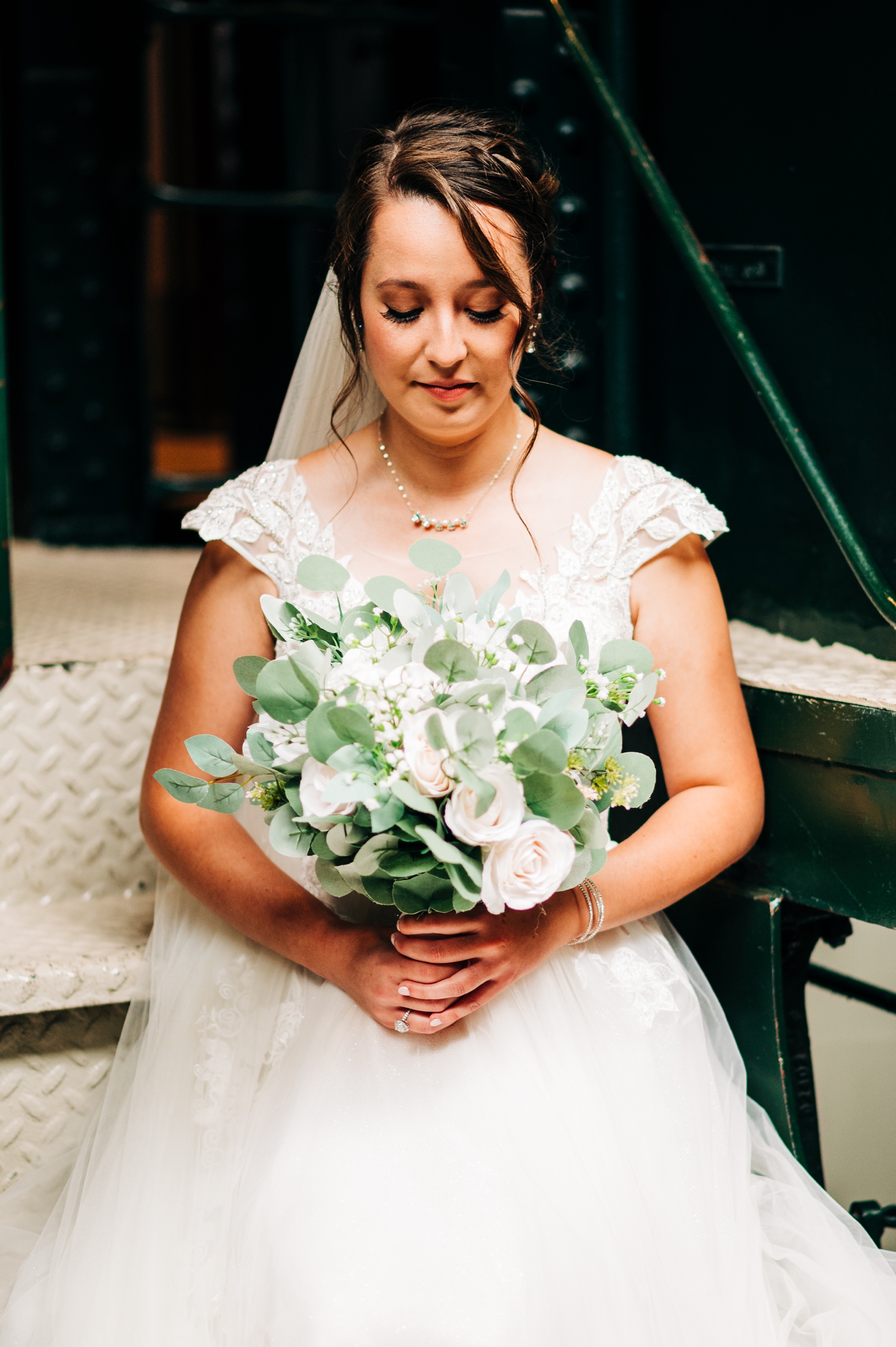 Bride with classic bouquet with ivory flowers and greenery