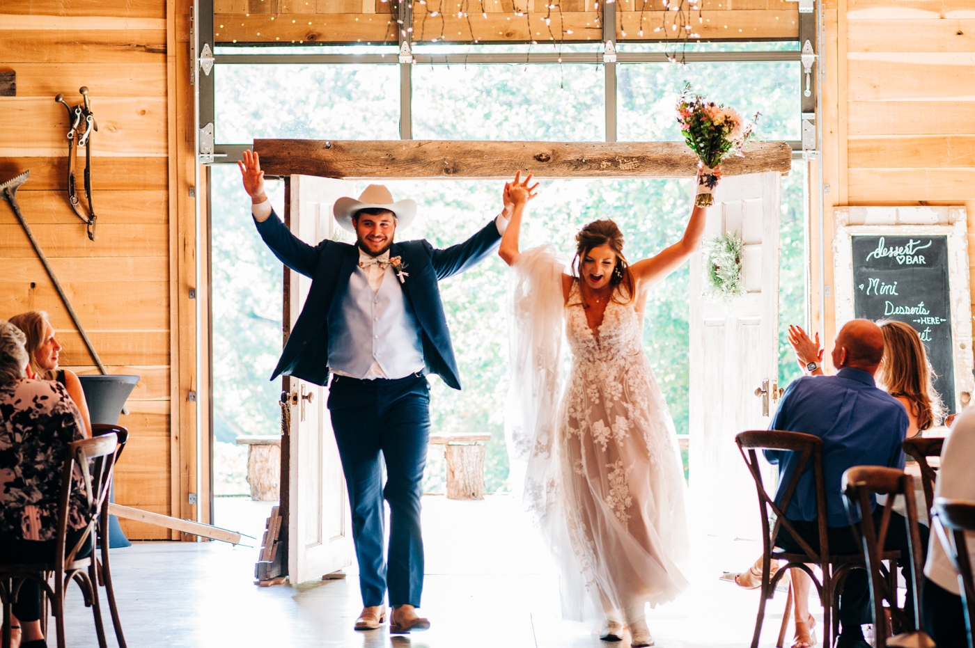 Bride and groom entering rustic wedding reception at The Barn at Timber Ridge