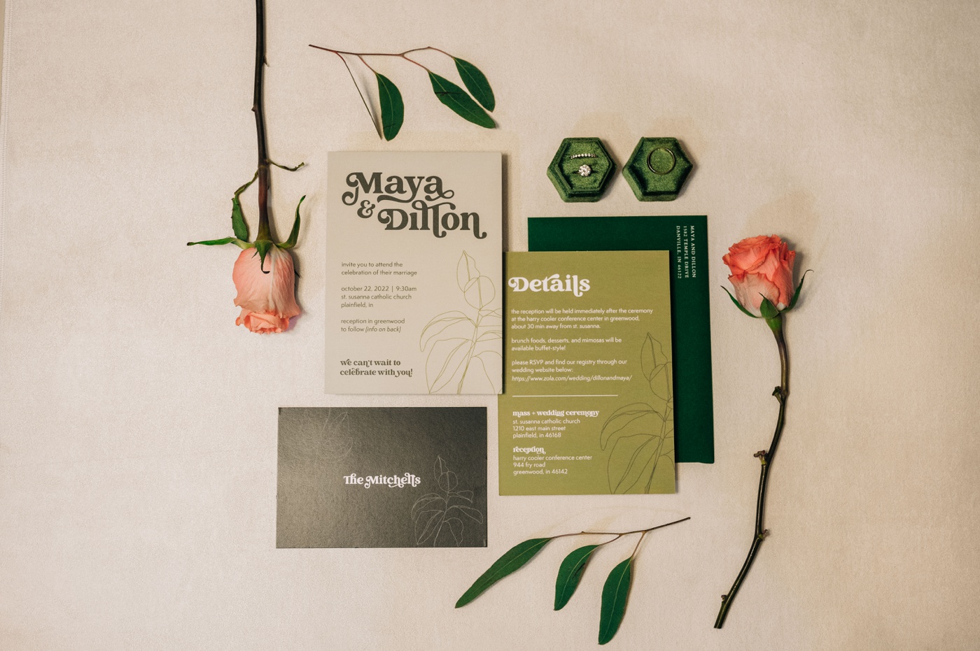 Flat lay of a green and white wedding invitation with a leaf illustration and pink roses