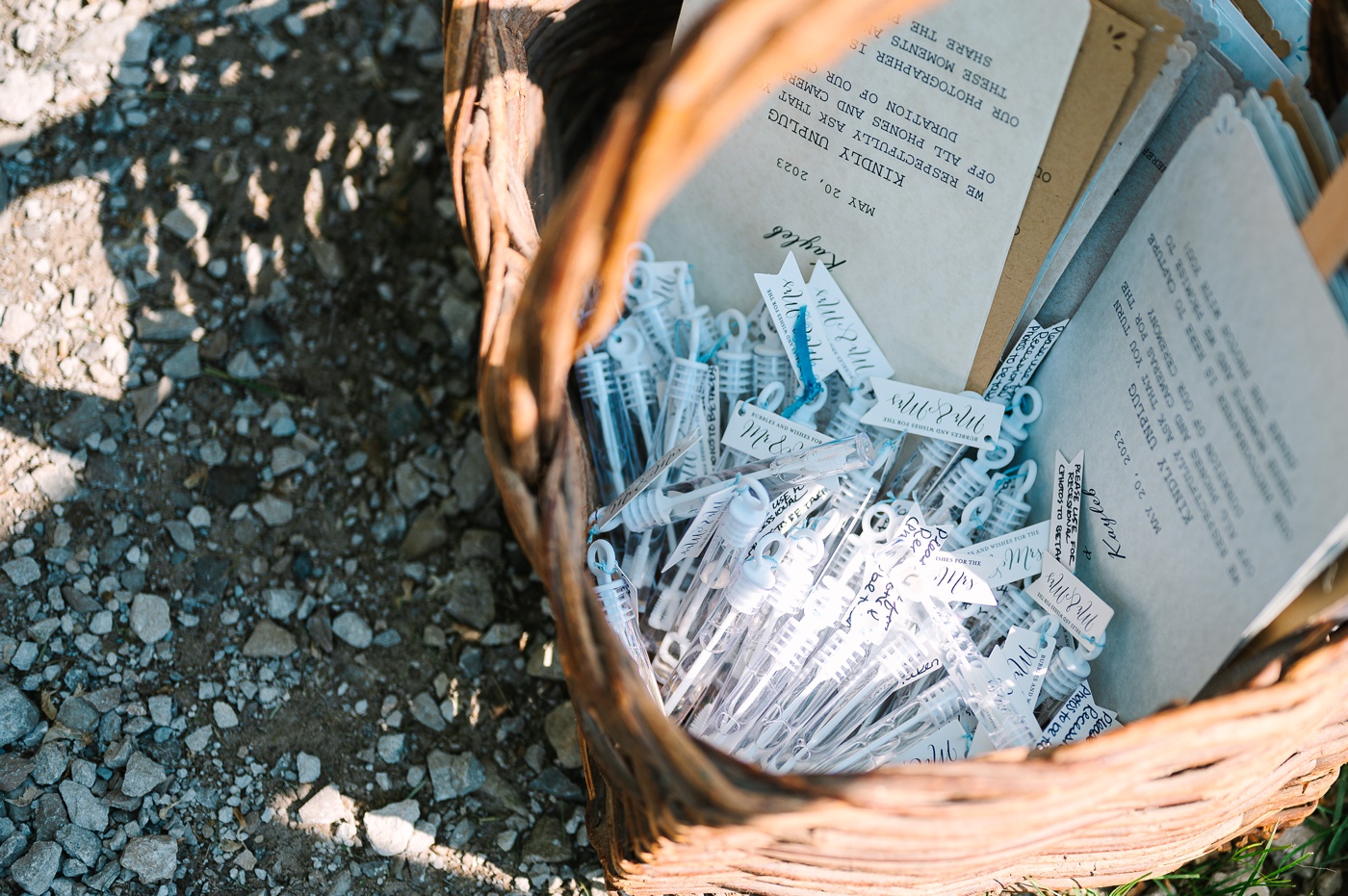 Basket with miniature bubble wands at an outdoor wedding ceremony