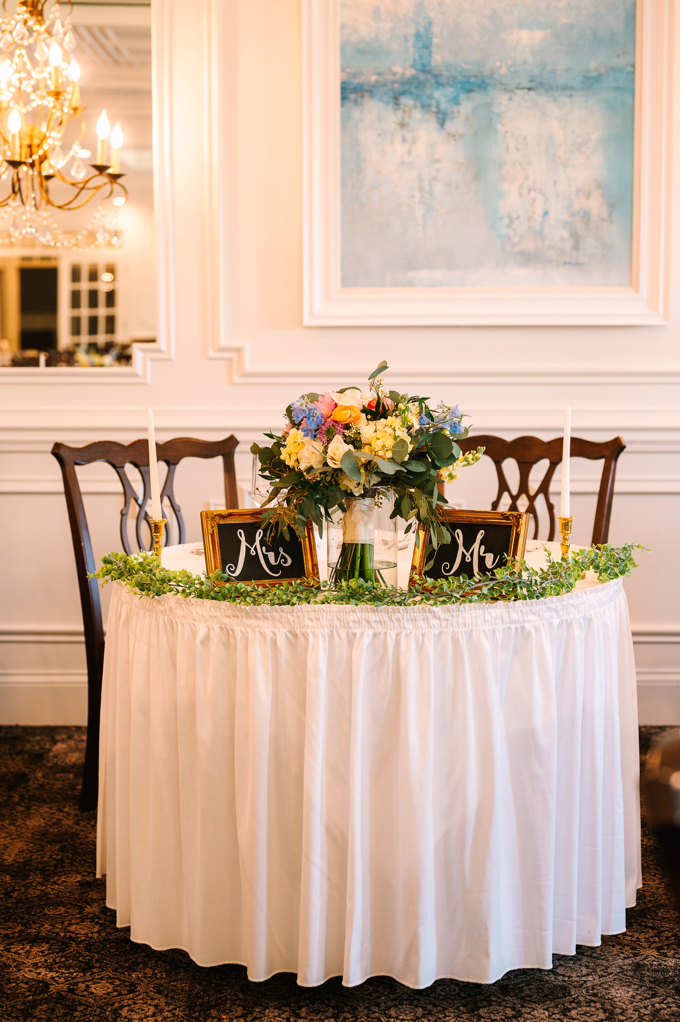 Sweetheart table with gold candlesticks and greenery