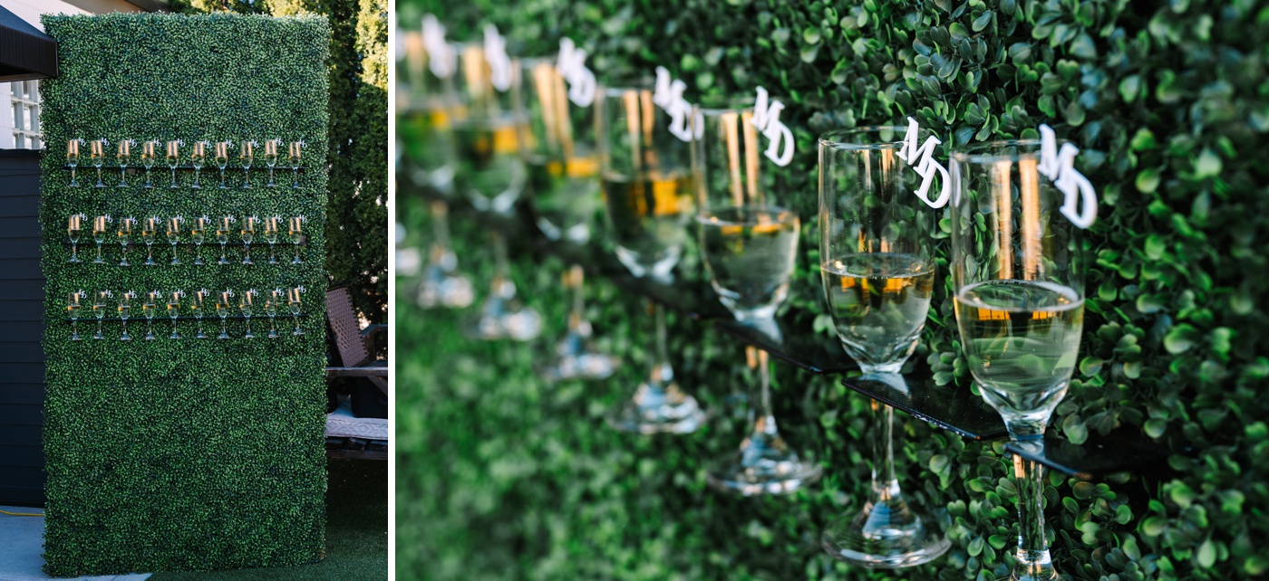 Greenery wall with custom initial champagne glasses at an Indianapolis wedding