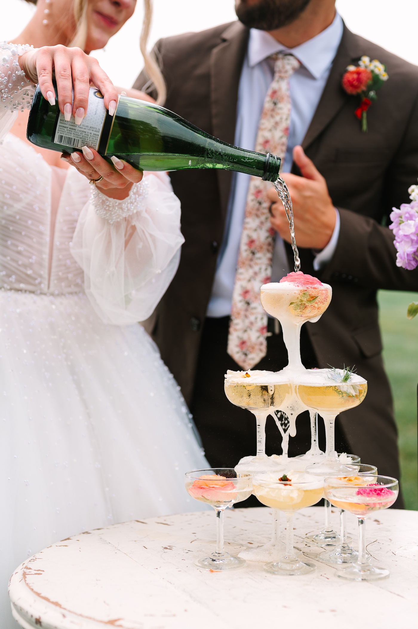Bride pouring into a champagne tower at Mustard Seed Gardens