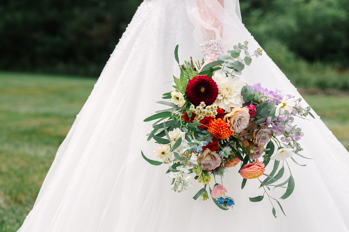 Spring wedding bouquet filled with dahlias, ranunculus, and cosmos by June Daisy Co.