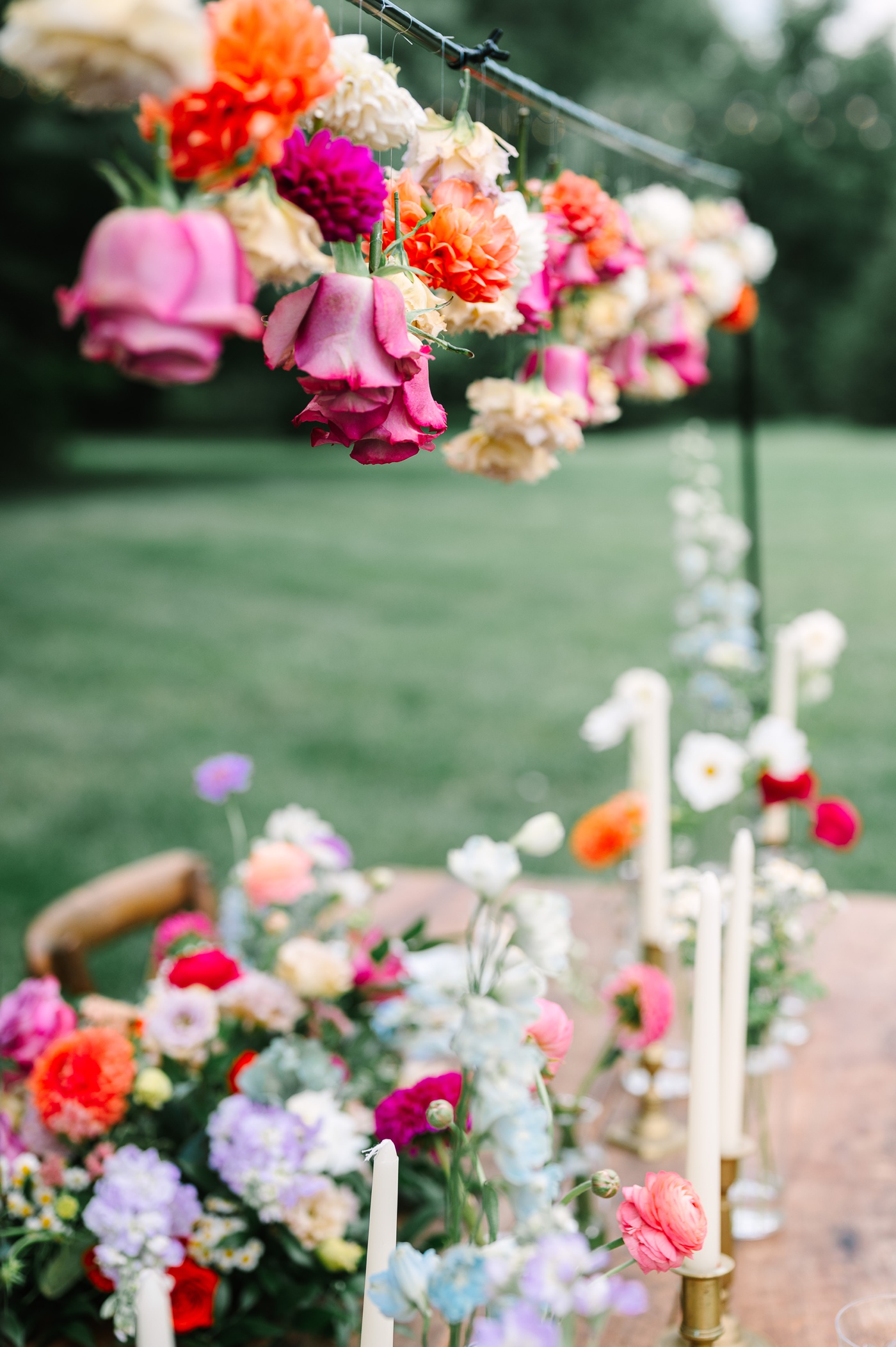 Pink and orange floral garland suspended above an outdoor table
