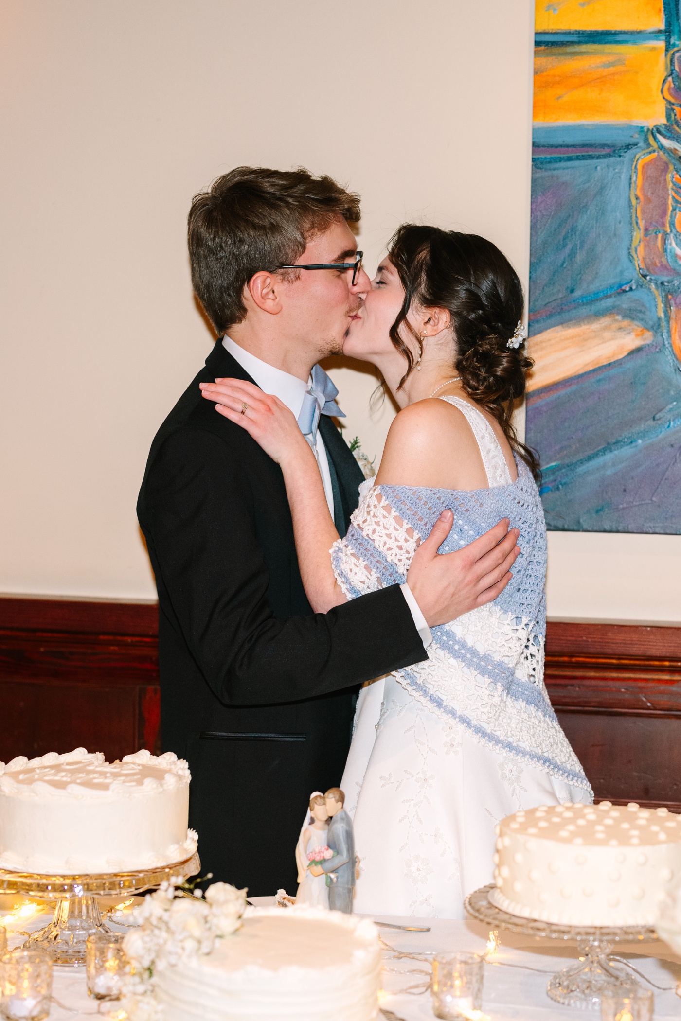 Bride and groom kissing after cutting their wedding cake