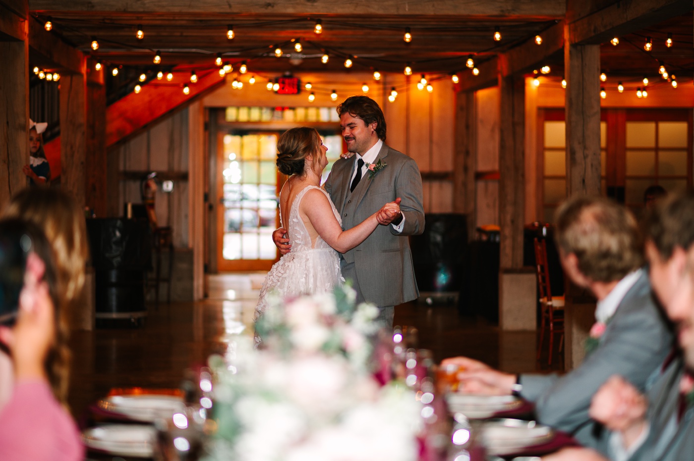 Bride and groom sharing their first dance in the reception barn at Whippoorwill Hill