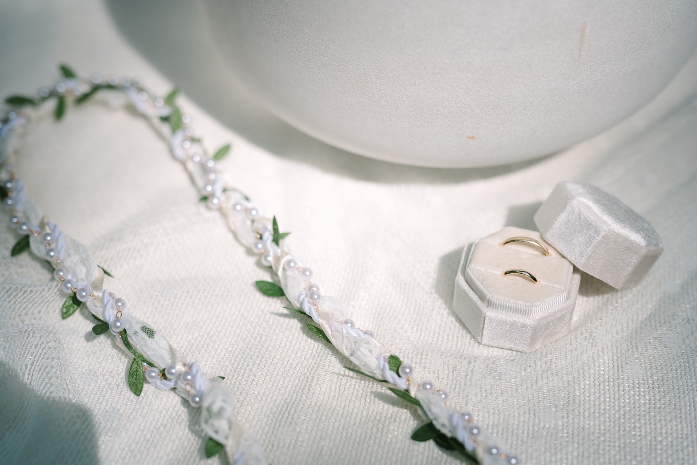 Flatlay of a handfasting cord and wedding rings