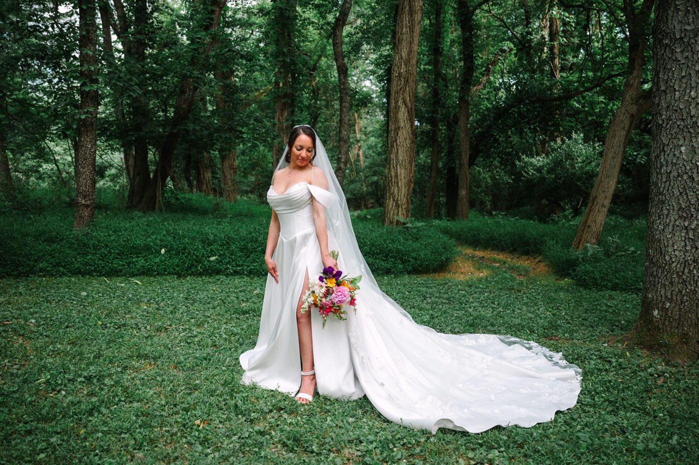 Bride wearing an off-shoulder wedding dress and holding a colorful bouquet